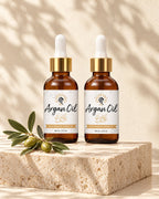 Two bottles of Argan Oil on a travertine pedestal beside an argan sprig