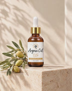 Hands unscrew the argan oil dropper on a travertine pedestal and close it again as soft leaf shadows move across the wall